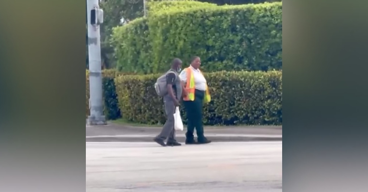 ciji crawford helping a blind man cross the road.