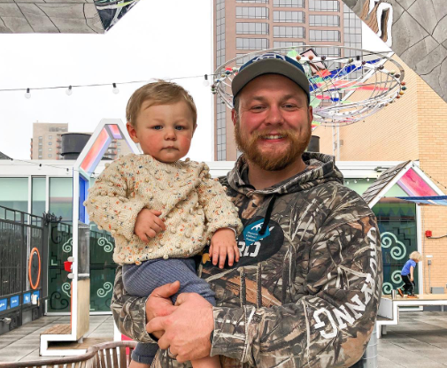 In this Tuesday, Oct. 23, 2018, photo Andrew Goette and his wife, Ashley,  look at their baby, Lennon, at United Hospital in Saint Paul, Minn. Andrew  awoke from a medically-induced coma just