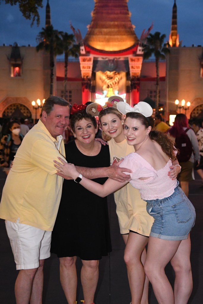 Jane Treacy smiles and poses with her husband and two daughters at Disney.