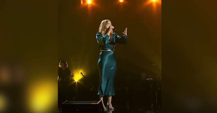 woman in green dress sings onstage