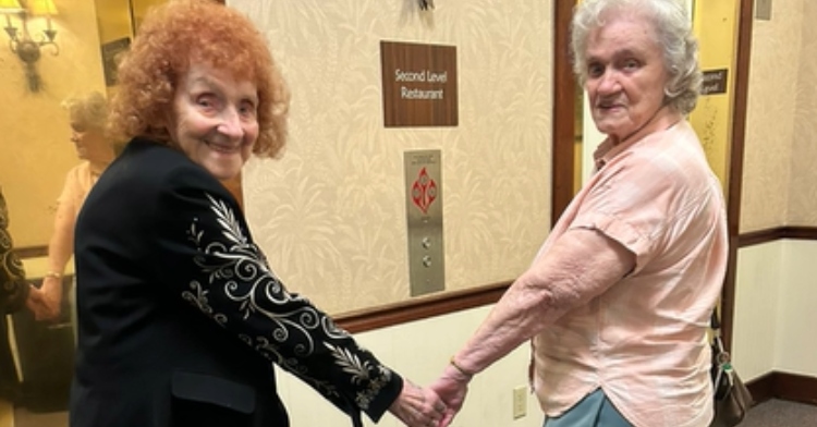 Barbara Carolan and Shirley smiling and holding hands as they wait for an elevator the day they reunited in 2023.
