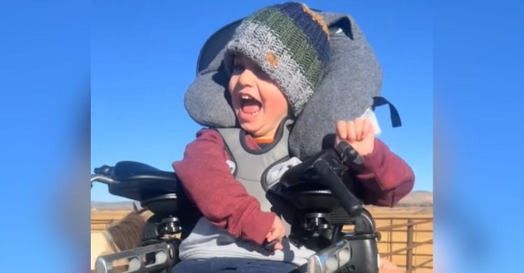 A young boy with cerebral palsy sits in an adaptive saddle.