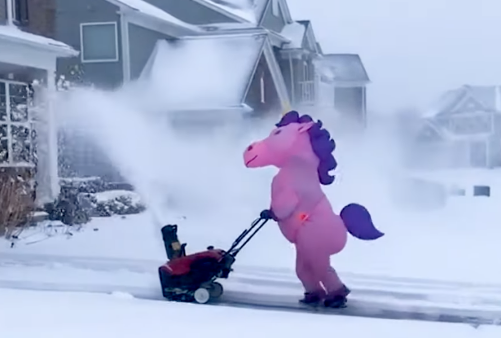 funny neighbor snowblowing in a unicorn costume