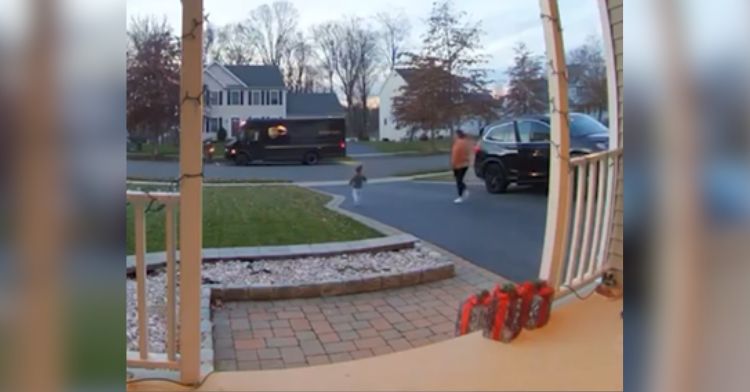 A little boy runs across the street to greet the UPS driver.