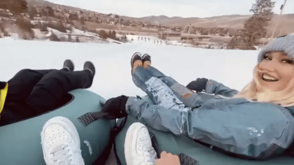 Gwen Stefani looks back and smiles as she goes snow tubing with her son.