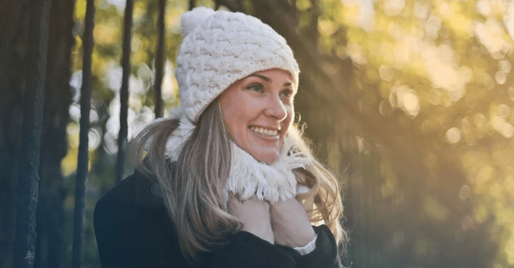 Woman wearing winter hat and scarf outside