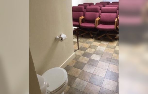 This design fail shows a seating area/presentation space with a toilet in the front of the room.