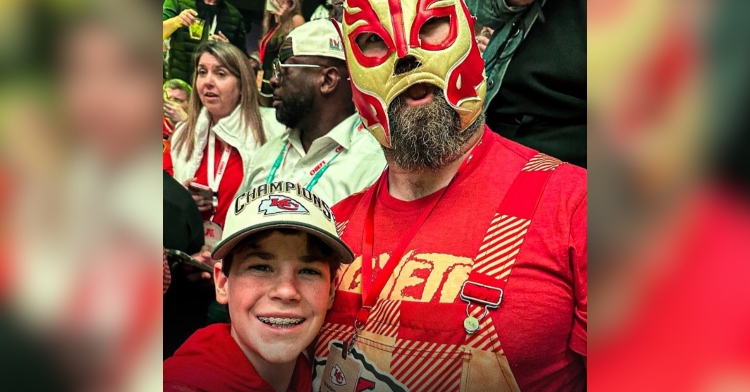 Jason Kelce smiles while wearing a luchador mask as he poses with eighth-grade fan Elijah Smith.