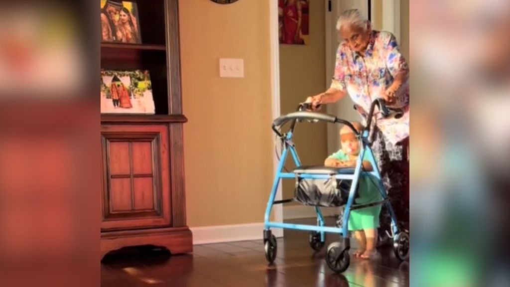 A great-grandma and her baby use the same walker to get around the house.