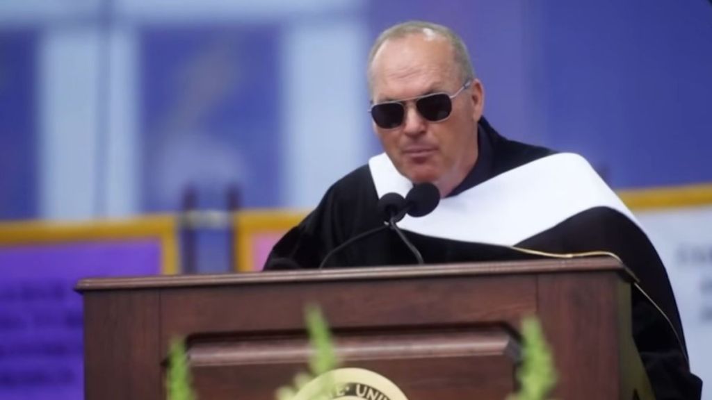 Image shows Michael Keaton at the podium during a 2018 graduation speech at Kent State University.