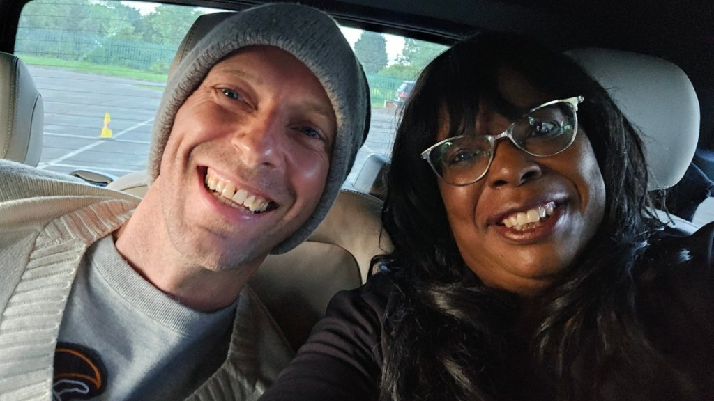Chris Martin smiles in the back of a car for a selfie with a fan, Saundra Glenn.