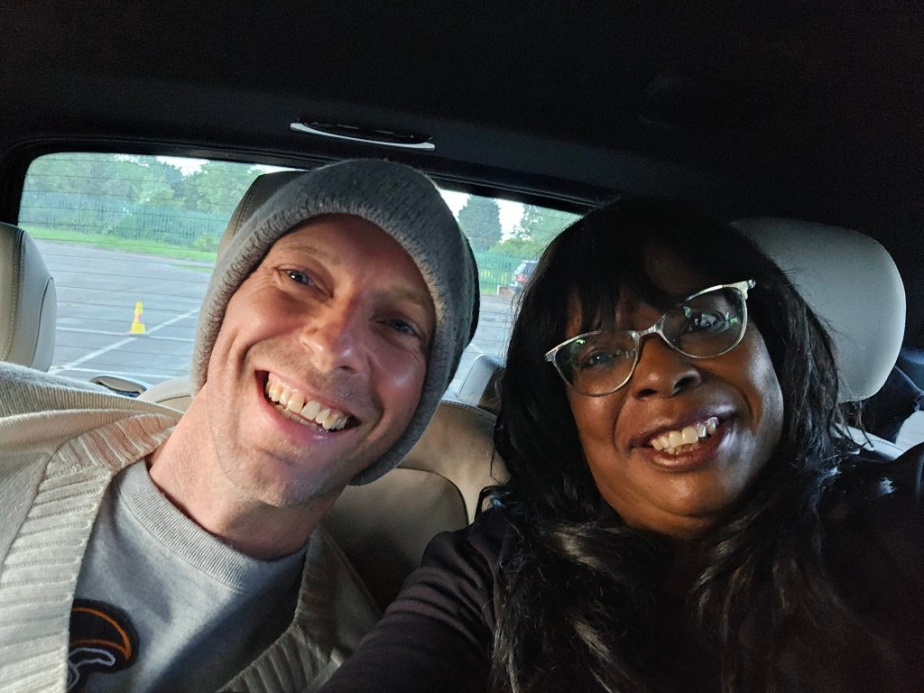 Chris Martin smiles in the back of a car for a selfie with a fan, Saundra Glenn.