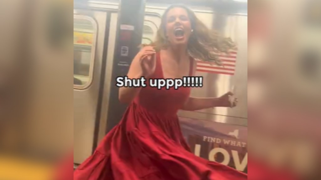 A woman mid-twirl smiles wide, mouth open. She's standing in a subway station in NYC. Text on the image shows what she's saying: Shit uppp!!!