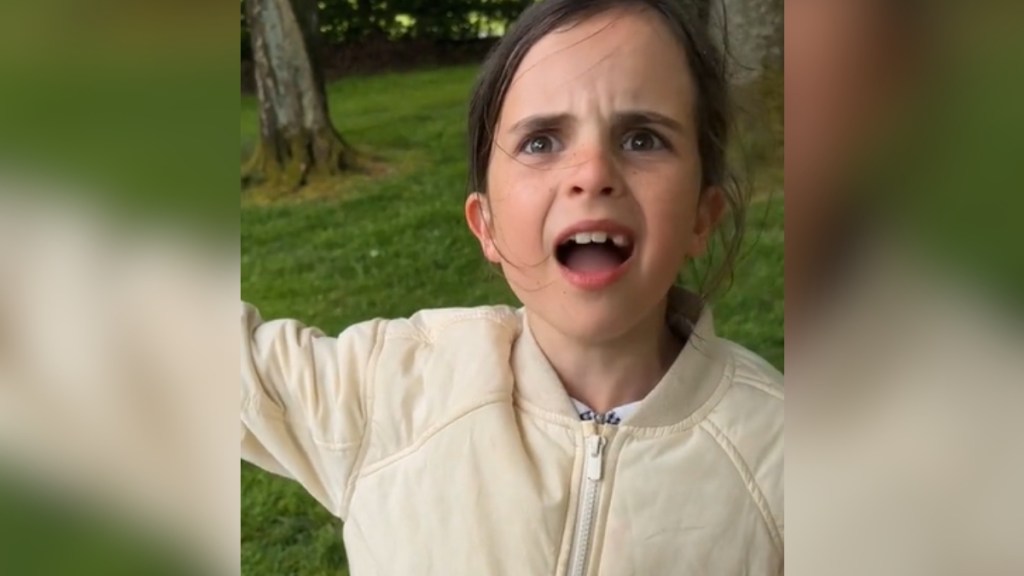 A little girl's mouth is wide open, a frustrated look on her face, as she rants