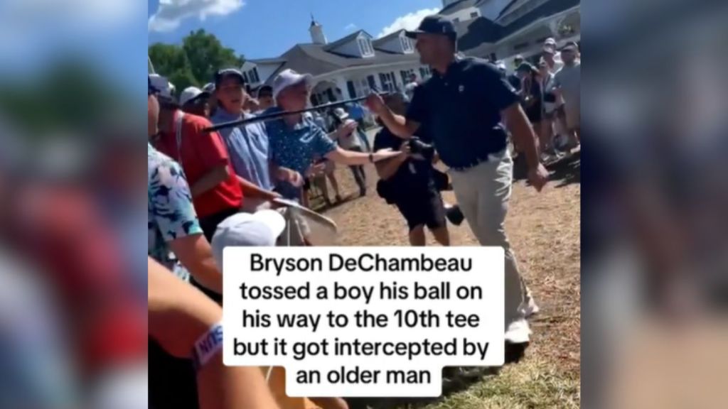 Bryson DeChambeau points his golf club at someone in the crowd.