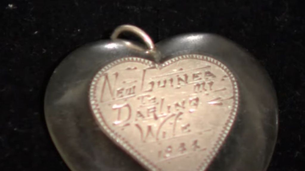 A heart-shaped, engraved pendant on a dark background.