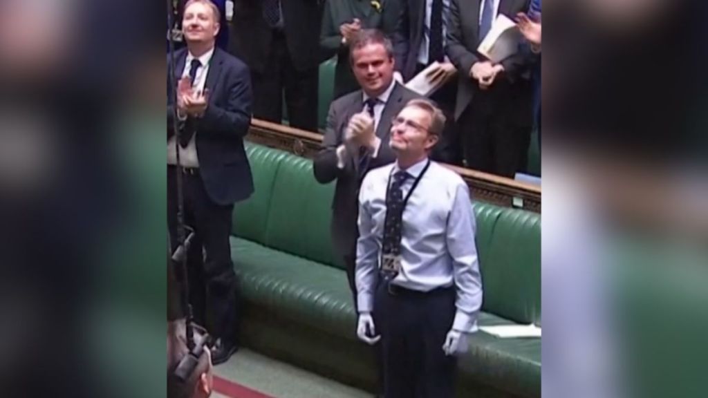 A politician receives applause while returning to work with prosthetic hands and feet.