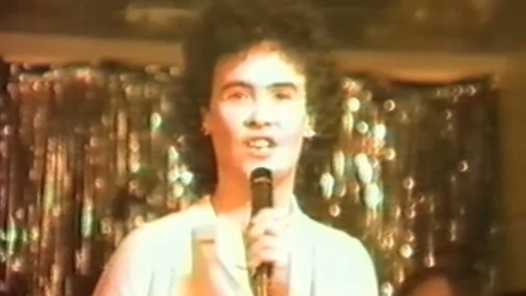 Susan Boyle in 1984 singing into a mic.
