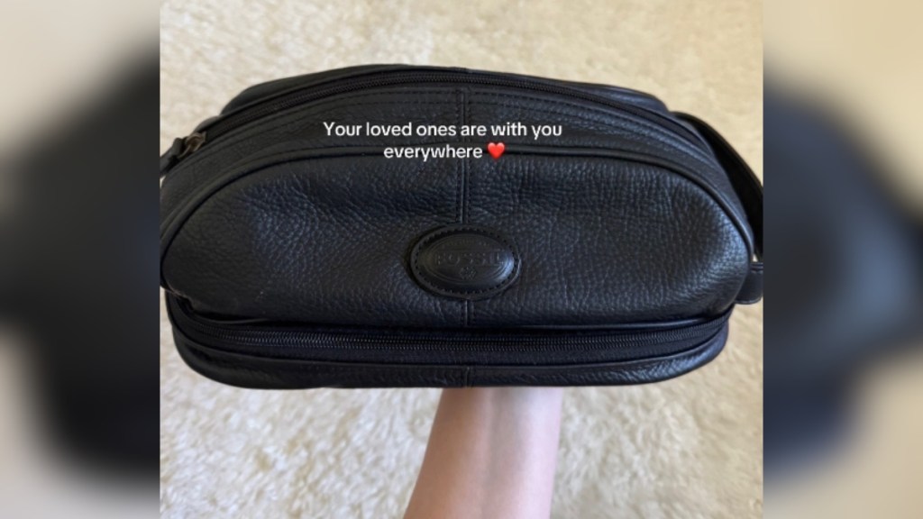 Close up of a black vintage purse that someone is holding. Text on the image reads: Your loved ones are with you everywhere.