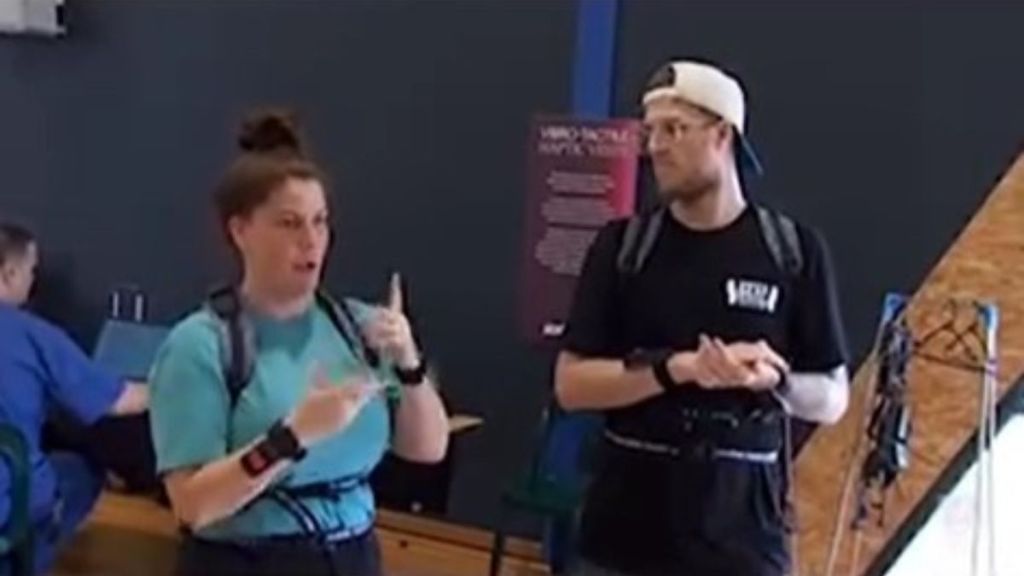 Image shows two deaf people wearing concert vests and dancing to music they "hear" through vibrations.