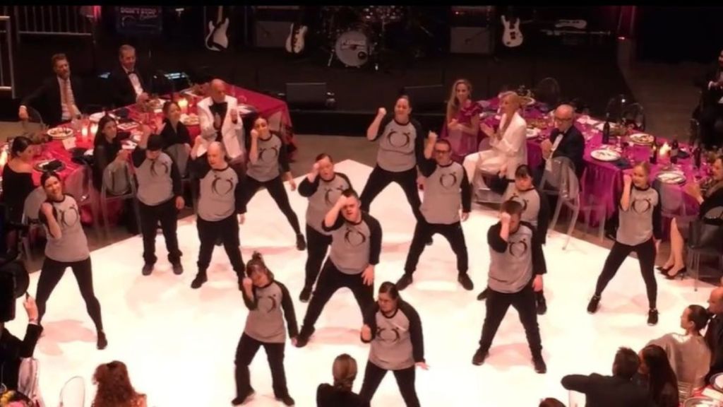 Image shows Down for Dance students performing on a lighted stage.