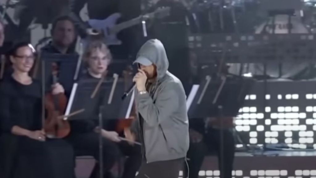 Image shows rapper Eminem on stage with the Detroit Symphony during the grand re-opening celebration of Michigan Central Station.