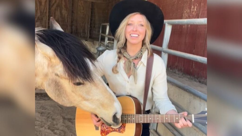 Image shows musician Mikayla giving a guitar lesson to Yupia the horse.