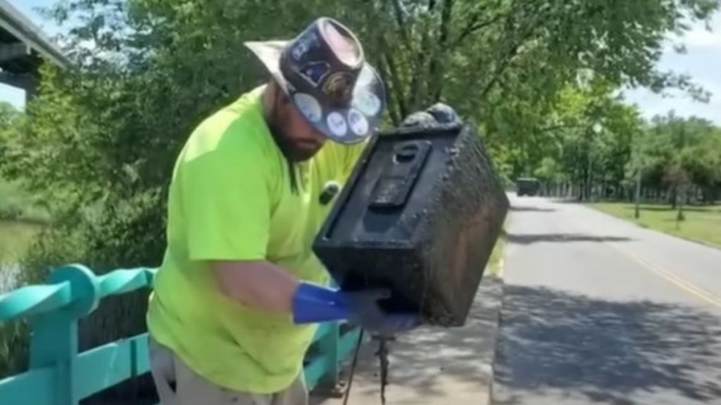 Image shows a man magnet fishing who found an intact safe.