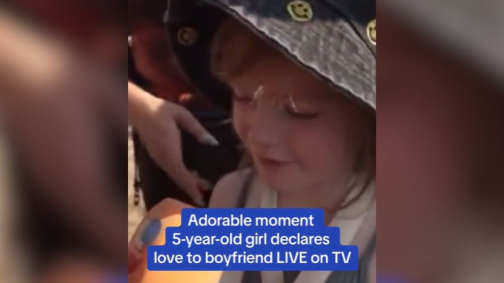 A little girl talking into a microphone outdoors.