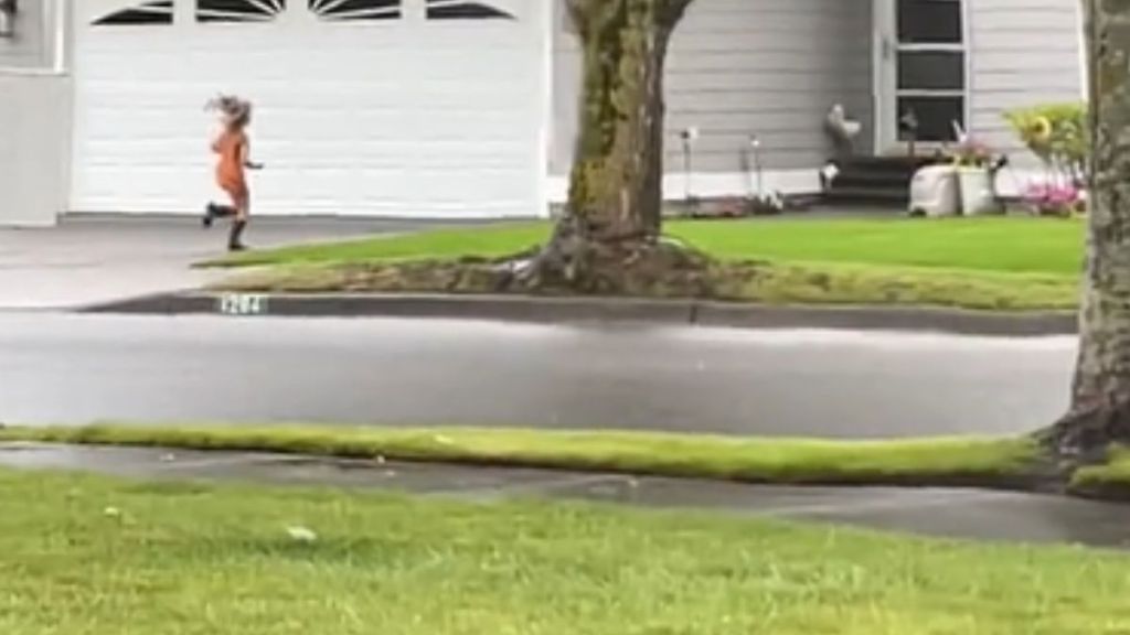 A little girl running down the driveway to a neighbor's house.