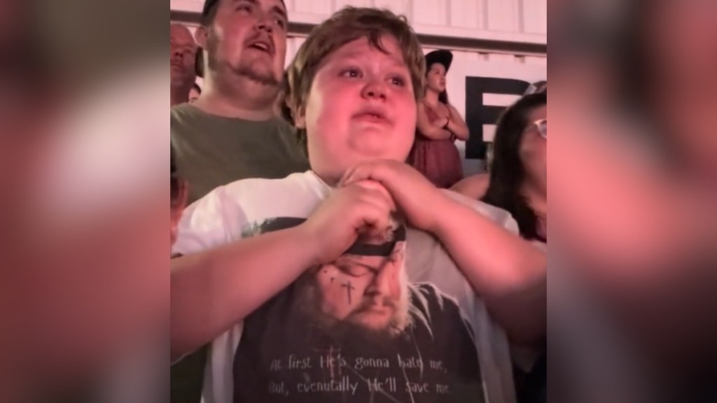 Little boy cries in a crowd at a Jelly Roll concert.
