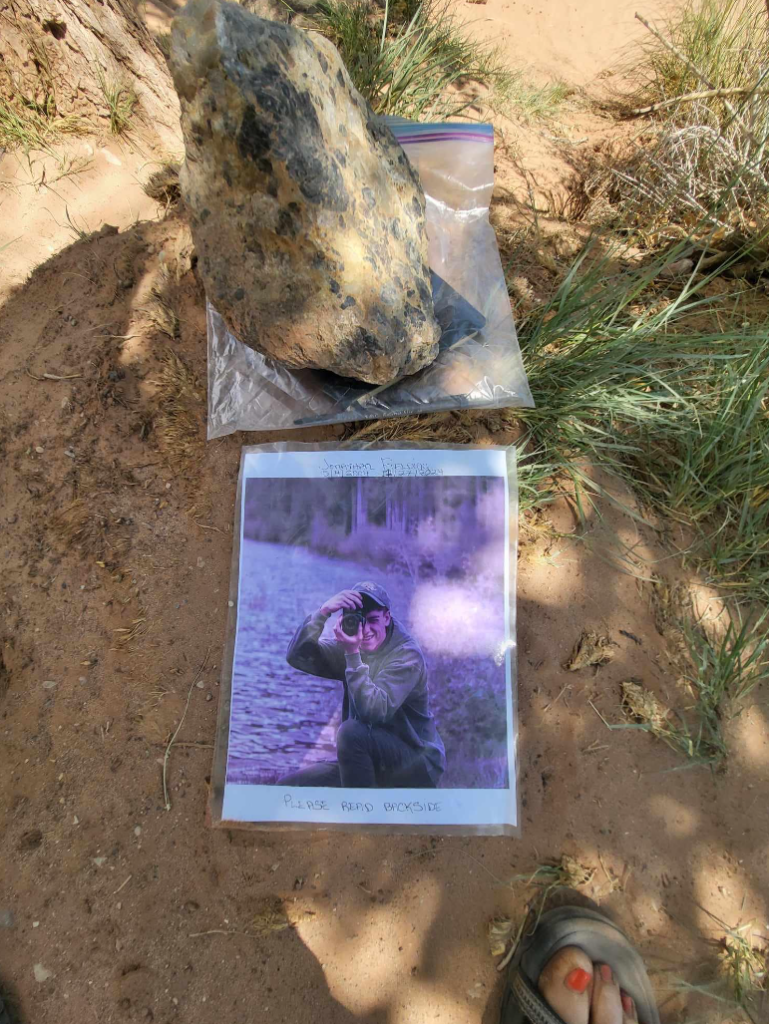 a photo of jonathan on the ground near a rock