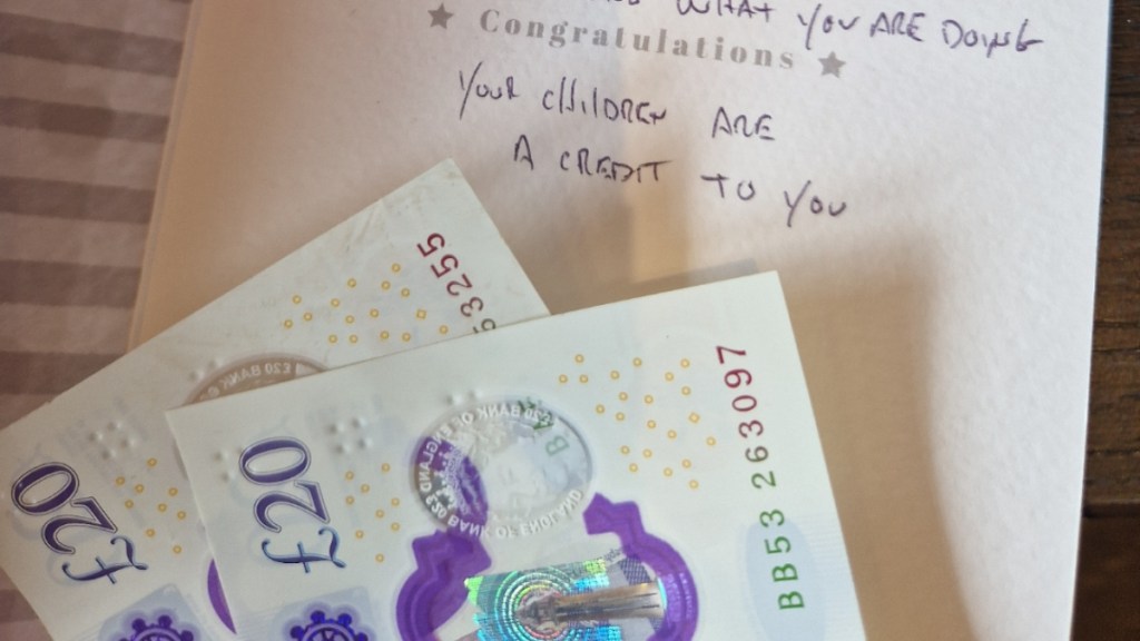 View of cash inside a card. Part of the message reads: Your children are a credit to you