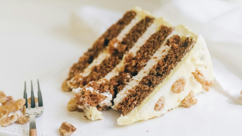 A slice of carrot cake with a fork next to it