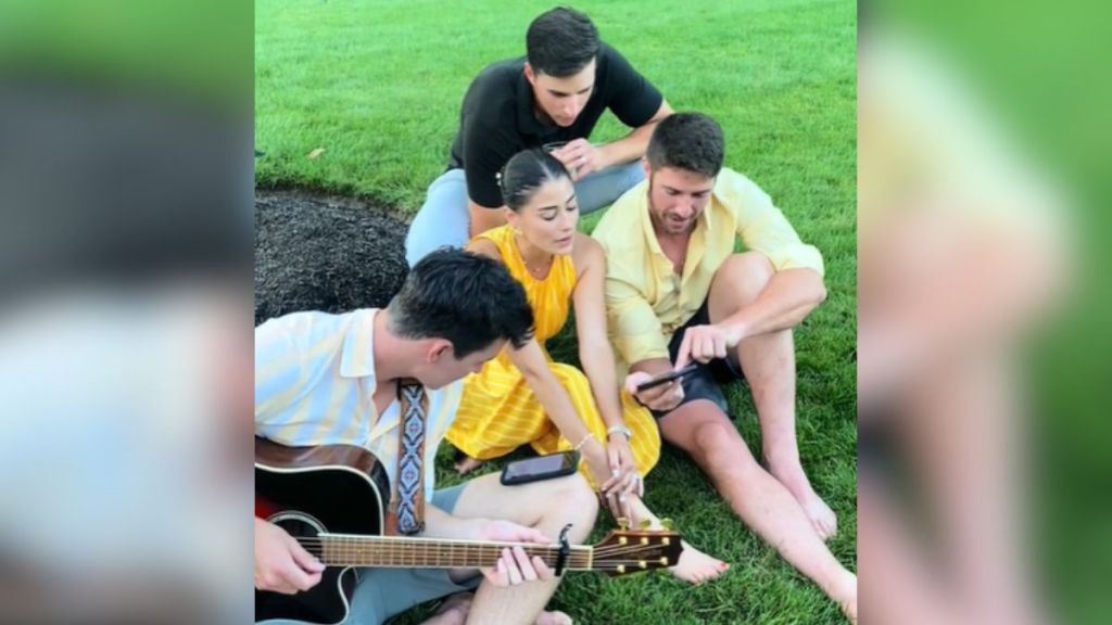 A group of people singing outdoors with guitars.