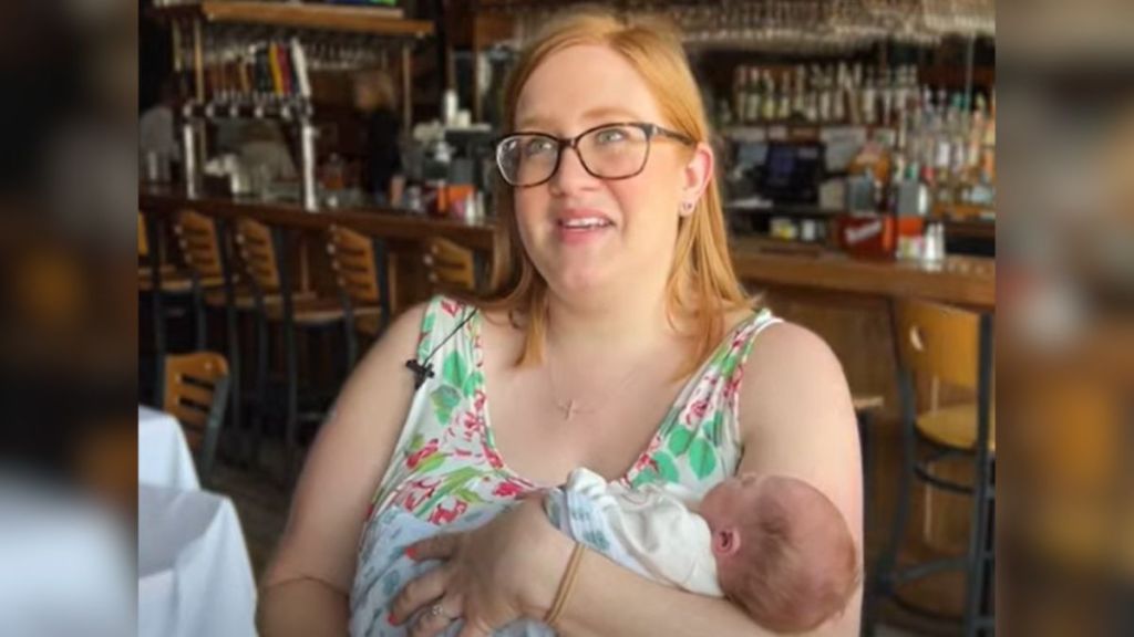 A mom holding her baby in the restaurant where she was born.