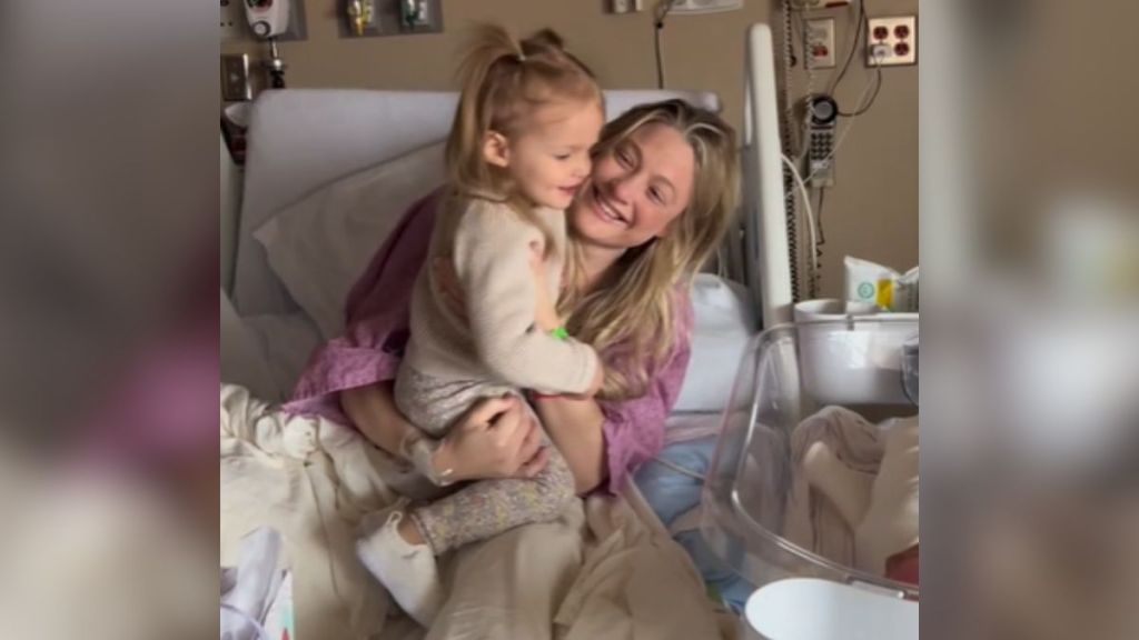 A woman in a hospital bed holding her toddler.