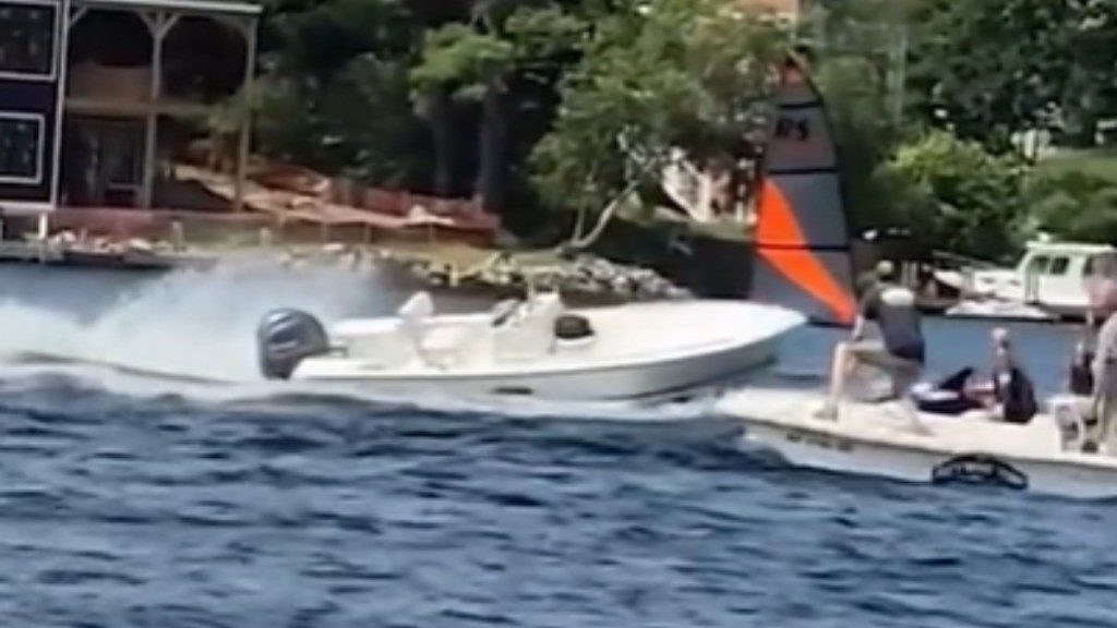 View from a distance of an unmanned boat starting to pass a family on a boat