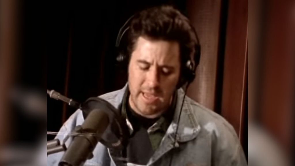 Vince Gill singing in a recording studio.