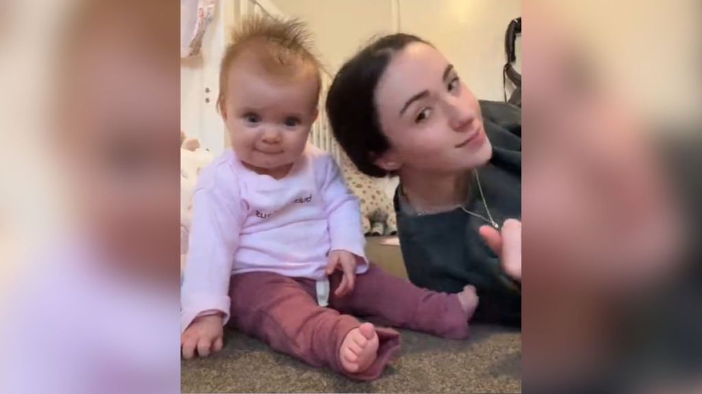 A woman laying her head in her baby's lap.