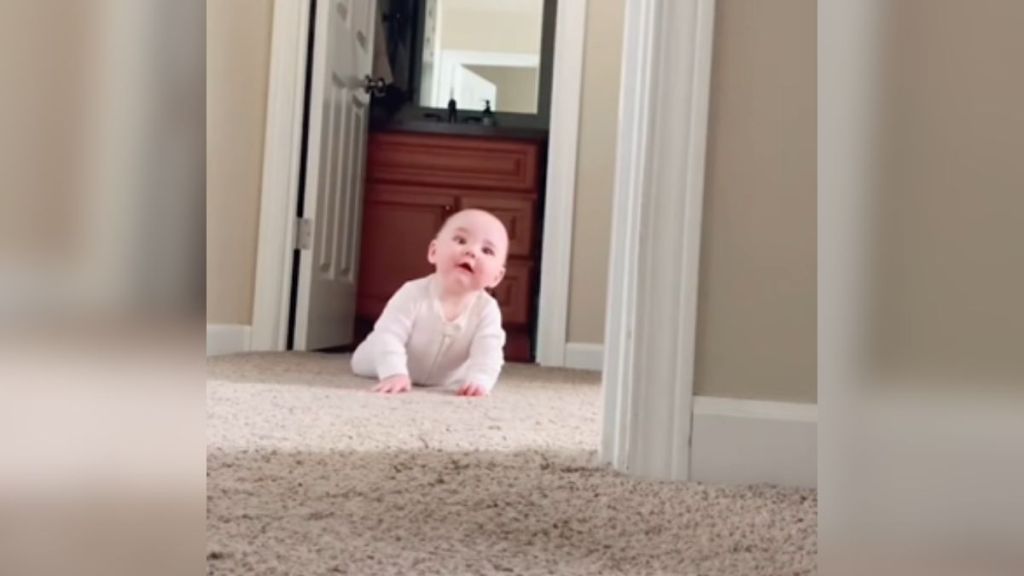 A baby laying on the ground and looking confused.