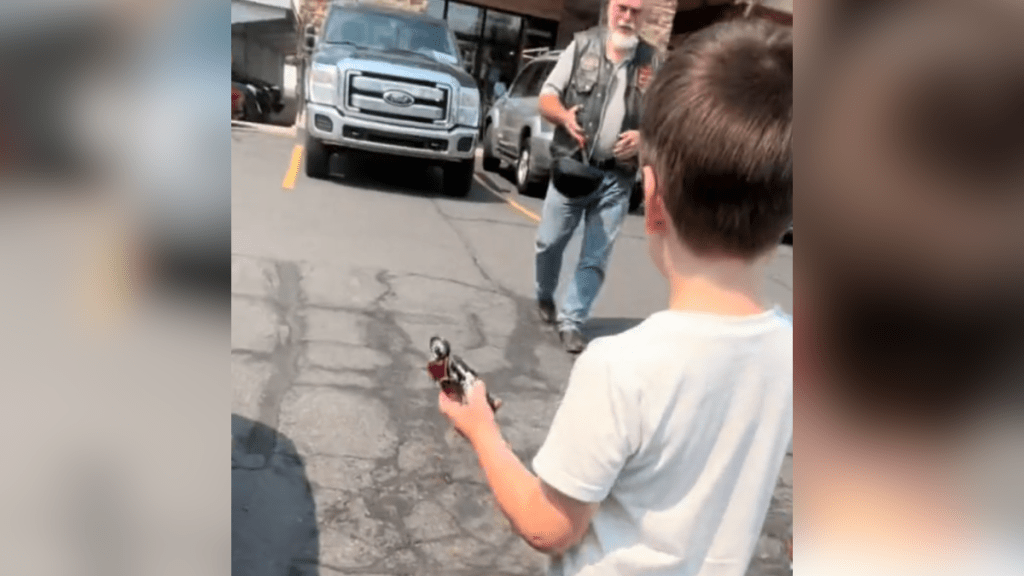 young boy who sees a biker and wants to exchange stickers.