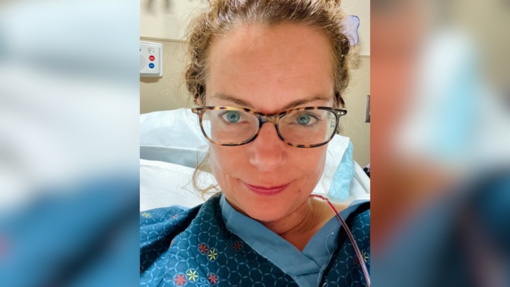 Selfie of Kimberly Williams-Paisley in a hospital bed. She has a small smile on her face