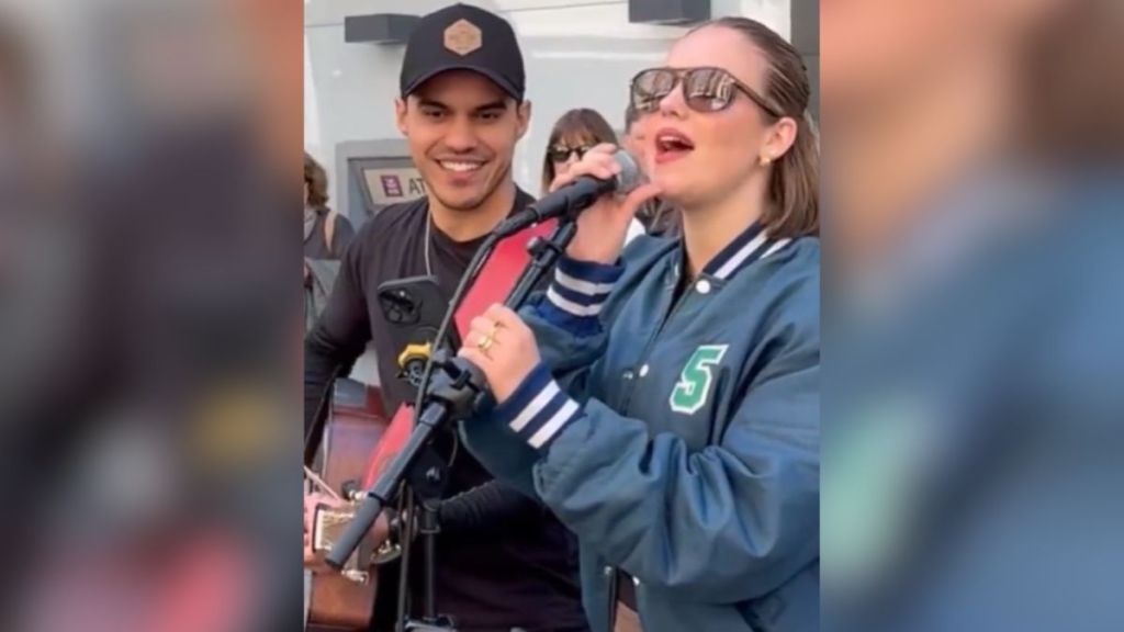 A woman singing while a man plays guitar.