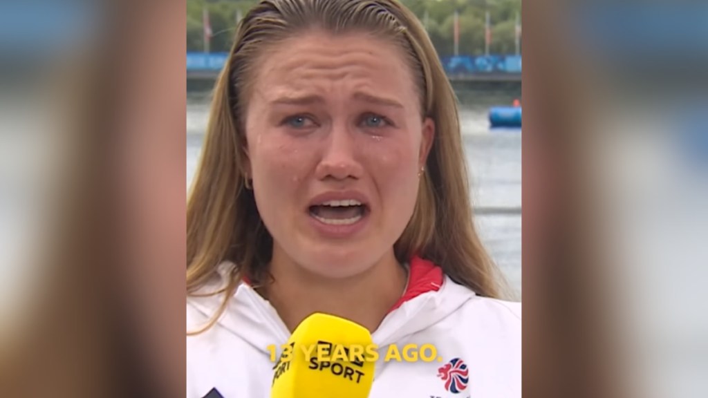 Close-up of Lola Anderson crying as she talks into a mic. Text on the image reads "13 years ago"