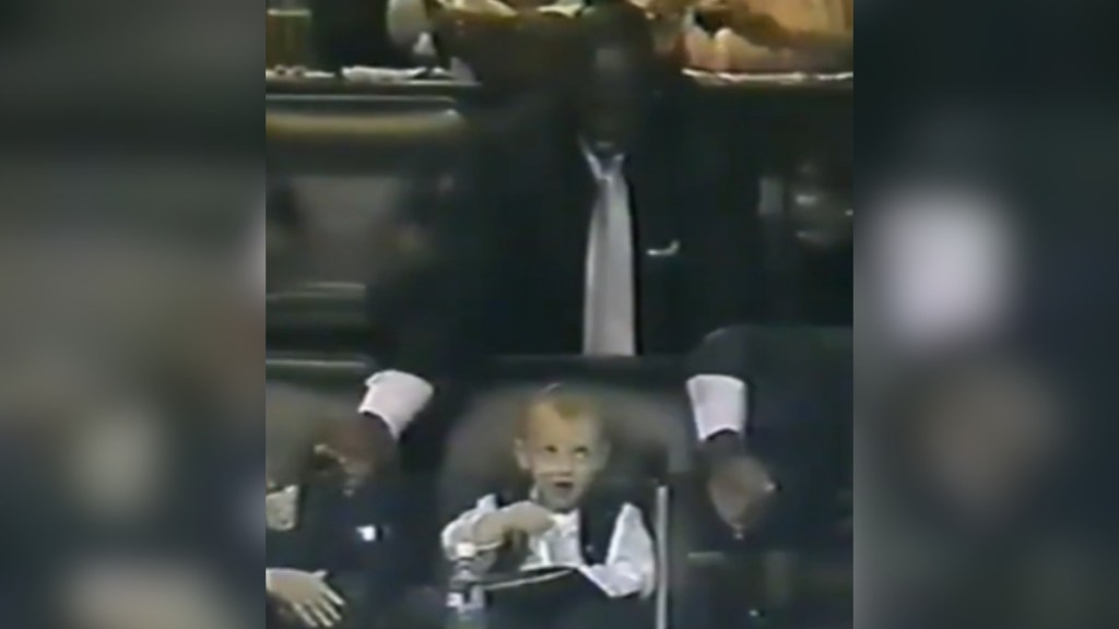 Old footage of Michael Jordan standing behind Katie Ledecky as a toddler. She looks up at him right after he moved his hands away from her face. He's smiling down at her