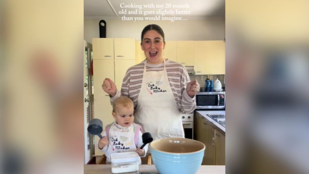 A mom and her toddler baking together in the kitchen.