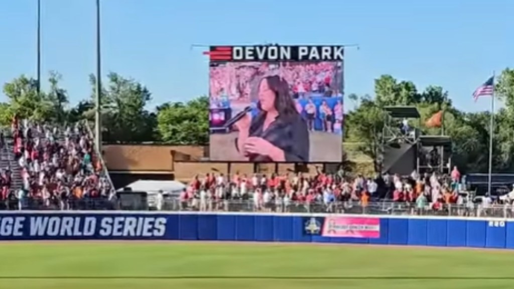 View of a large screen at a softball game. The screen shows Krystal Keith, Toby Keith's daughter, singing