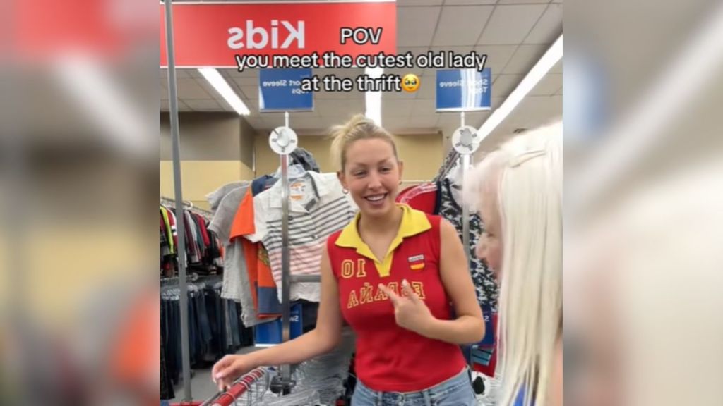 A young woman speaking to an elderly woman in a clothing store.