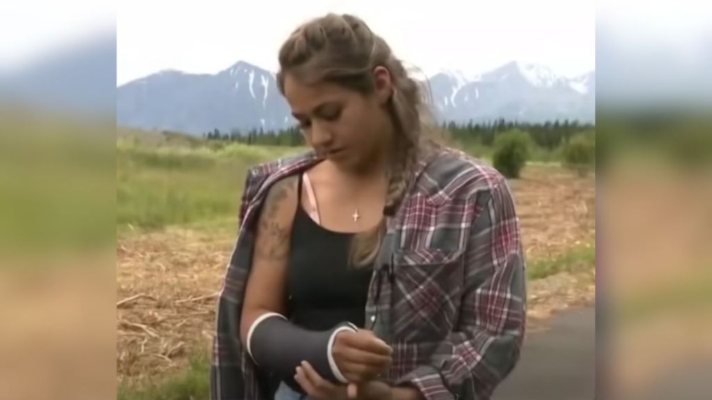 A woman outdoors wearing a cast on her arm.